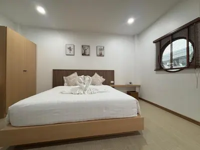 a bedroom with a bed with a flower on it at Falisa House Apartment Bangtao in Ban Thalat Choeng Thale