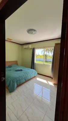 a bedroom with a green bed and a window at Liina House in Ko Yao Noi