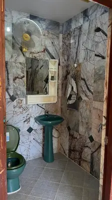 a bathroom with a green toilet and a sink at Liina House in Ko Yao Noi