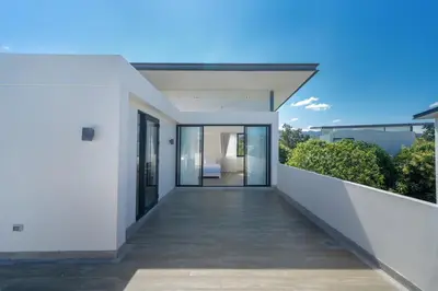 a balcony of a house with white walls and glass doors at Friendly Lux 5 Bedroom Villa Laguna park in Laguna Phuket