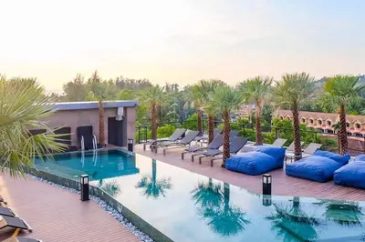 a pool at a resort with palm trees at 2 BR Pool View in Wellness Residence near Beach P503-4 in Kamala Beach