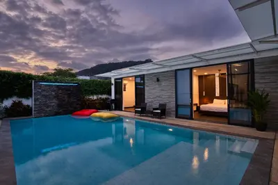 a swimming pool in front of a house at Prestige 4BR Private Pool Residence in Rawai in Ban Kata