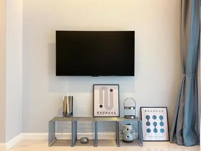 a living room with a television on a wall at The Pelican Residence & Suites Krabi in Ban Ko Kwang