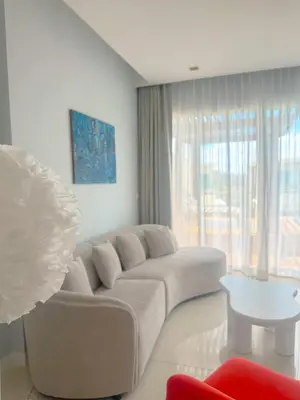 a white living room with a couch and a table at The Pelican Residence & Suites Krabi in Ban Ko Kwang