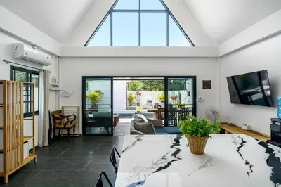 a living room with a table and a large window at Lili Villa by G Estate Phuket in Nai Harn Beach