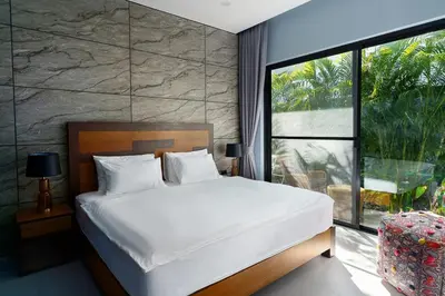 a bedroom with a large bed and a large window at Ramon Villa by G Estate Phuket in Ban Saiyuan (1)