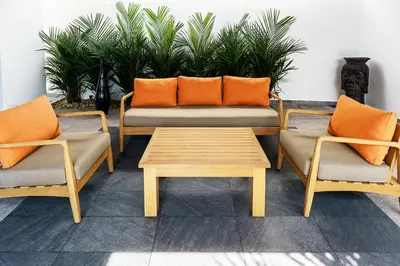 three chairs and a table and a couch with orange pillows at Ramon Villa by G Estate Phuket in Ban Saiyuan (1)