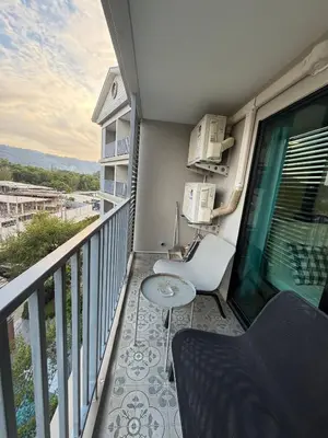 a balcony with a table and a chair at 1 BDR 5 Swimming Pool Entire Condo 5 Mins Walk To Naiyang Beach in Nai Yang Beach