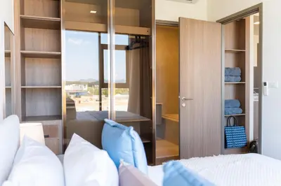 a bedroom with a bed and a sliding glass door at Canvas Cherngtalay Holiday Apartments in Laguna Phuket
