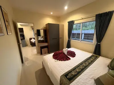 a bedroom with a bed and a large window at Cozy 2-Bedroom Place in a Quiet Area Nearby Beach in Ban Lum Fuang