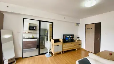 a living room with a television and a room with a couch at Vista Residence Old Town in Phuket Town