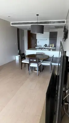 a dining room with a table and chairs and a kitchen at 1 bedroom apartment Laguna bangtao in Laguna Phuket