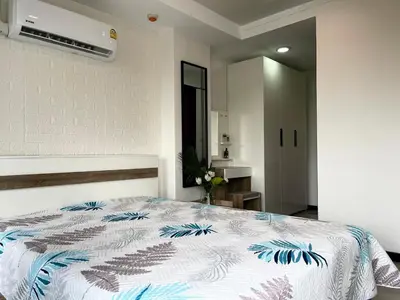 a bedroom with a bed with a blue and white comforter at Rawai Beach Condom in Ban Saiyuan (1)