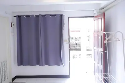 a bathroom with a blue shower curtain next to a window at xx GO INN Patong Jangceylon - โกอินน์ ป่าตอง in Patong Beach