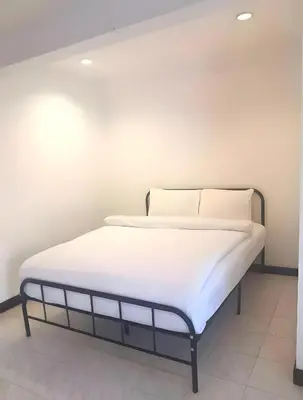 a bed with white sheets and pillows in a room at xx GO INN Patong Jangceylon - โกอินน์ ป่าตอง in Patong Beach