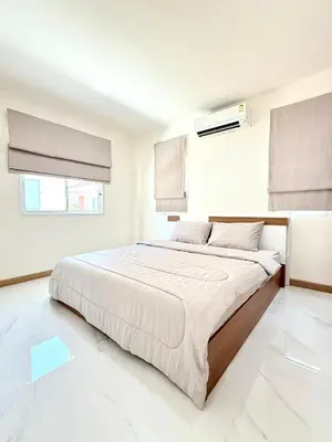 a white bedroom with a large bed in it at Harmony House in Ban Bang Khu