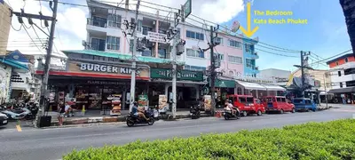 a busy city street with motorcycles driving past a building at Bedroom301 Kata Beach Phuket in Kata Beach