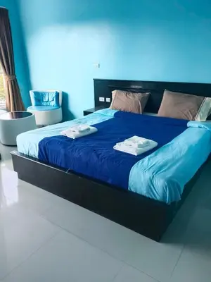 a large bed with blue sheets and towels on it at Bedroom401 Kata Beach Phuket in Kata Beach