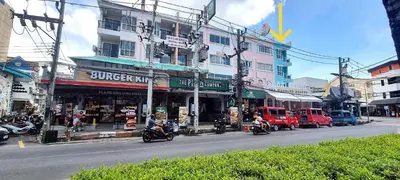 a busy city street with motorcycles driving past a building at Bedroom401 Kata Beach Phuket in Kata Beach