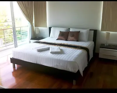 a large bed in a room with a large window at Euphoria Property in Kamala Beach