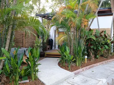 a garden with palm trees and a walkway at Studio in Phuket Nai Harn in Rawai Beach