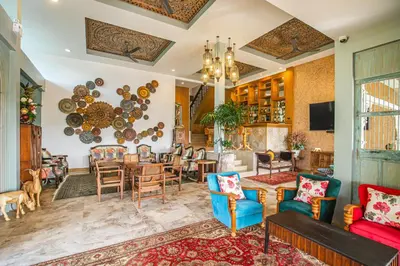 a living room with a table and chairs at Bell Seaside Residence in Rawai Beach