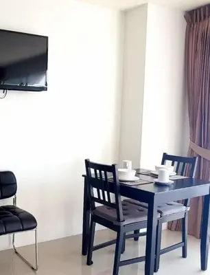 a dining room with a table and chairs and a tv at C257 Studio Seaview Near Beach Pool & Gym View in Patong Beach