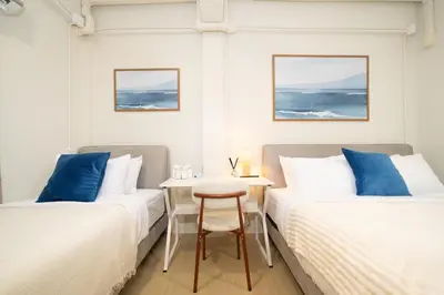 two beds in a room with a table between them at Spacious 8 Bedroom 20 Person Near Patong Beach in Patong Beach