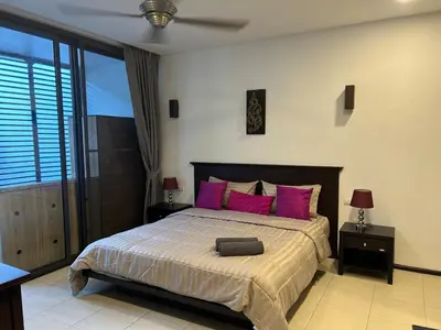 a bedroom with a large bed with pink pillows at Bangtao Beach Gardens 2 bedroom villa near Surin beach in Ban Lum Fuang