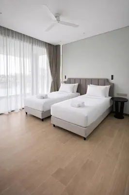 two beds in a hotel room with white furniture at Апартаменты в Angsana, Банг Тао in Laguna Phuket