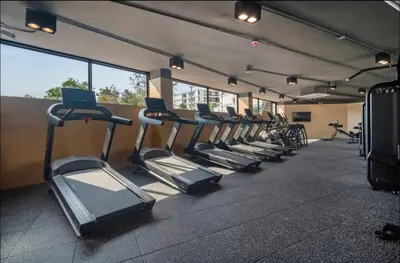 a row of treadmills in a gym with a laptop at Studio 50 meter from Layan Beach in Layan Beach