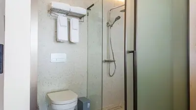 a bathroom with a shower and a toilet and towels at Studio 50 meter from Layan Beach in Layan Beach
