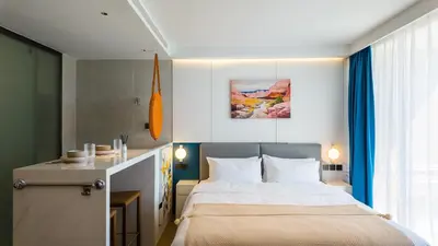 a bedroom with a bed and a desk and a window at Studio 50 meter from Layan Beach in Layan Beach