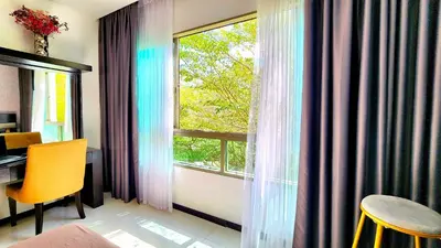 a room with a window with a desk and a table at Phuket Apartment Kamala Regent Condo in Kamala Beach