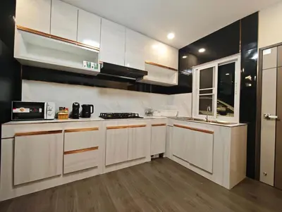 a kitchen with white cabinets and a sink and a microwave at JJame Pool Villa Patong in Patong Beach