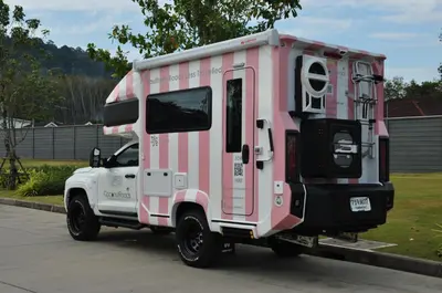 a pink truck parked in a parking lot at CoconutRoads Self Drive Motorhome in Phuket