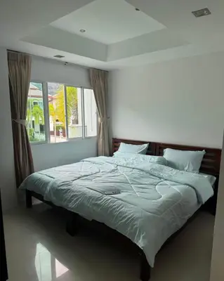 a large bed in a bedroom with a window at Kamala Cozy Townhouse in Kamala Beach