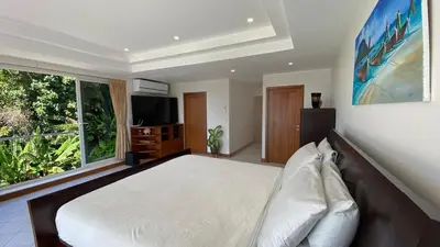 a bedroom with a large bed and a large window at Andaman hill pool Seaview three bedroom in Patong Beach