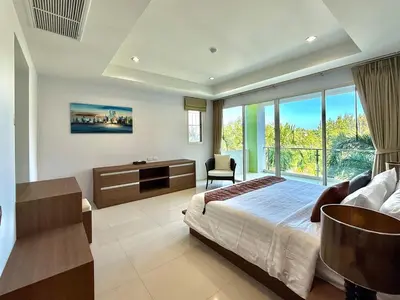 a bedroom with a bed and a large window at Bangtao Tropical Residence by Villacarte in Ban Lum Fuang