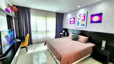 a bedroom with a bed and a flat screen tv at Phuket KAMALA Apartment in Phuket Town