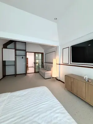 a large bedroom with a bed and a flat screen tv at Bernard Travel in Phuket Town