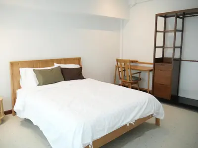 a bedroom with a large white bed and a desk at Bernard Travel in Phuket Town