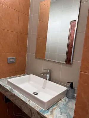 a white sink in a bathroom with a mirror at Bernard Travel in Phuket Town