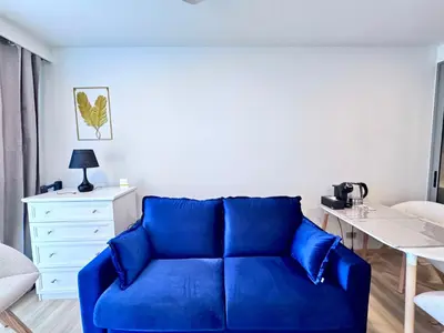 a blue couch in a living room with a table at Skypark New Building 4th floor Mountain View in Laguna Phuket