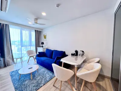 a living room with a blue couch and a table at Skypark New Building 4th floor Mountain View in Laguna Phuket