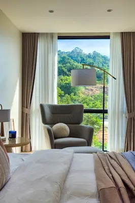 a bedroom with a bed and a chair and a window at Great Apartment Sea Heaven 2 min to Nai Thon Beach in Nai Thon Beach
