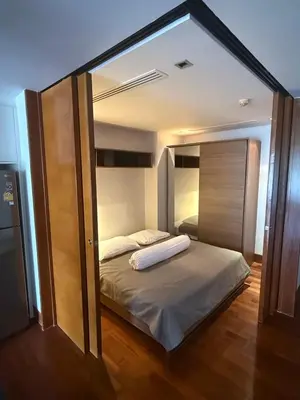 a bedroom with a bed with a large mirror at Beachfront 2BR Apartment with Pool View in Nai Thon Beach