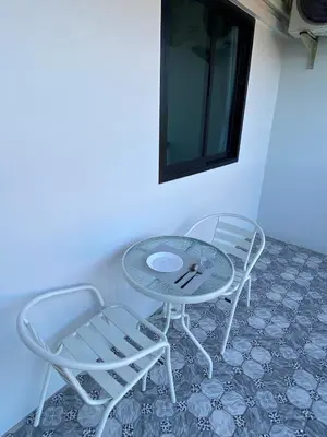 two chairs and a glass table and two chairs at Guest Room Bang Tao MMA in Ban Thalat Choeng Thale