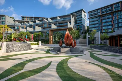 a park in front of a building with a sculpture at Ocean Horizon Residences - 2-BR, BangTao Beach in Ban Lum Fuang