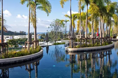 a pool of water with palm trees in it at Ocean Horizon Residences - 2-BR, BangTao Beach in Ban Lum Fuang